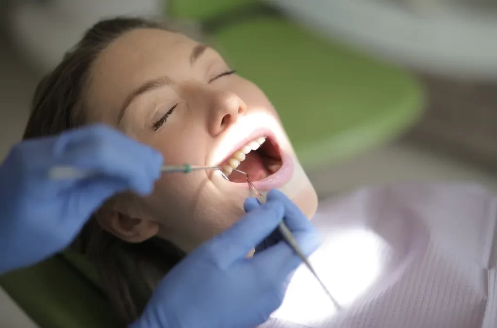 Dental professional evaluating and cleaning a patient's teeth during a deep cleaning visit in Flower Mound, TX