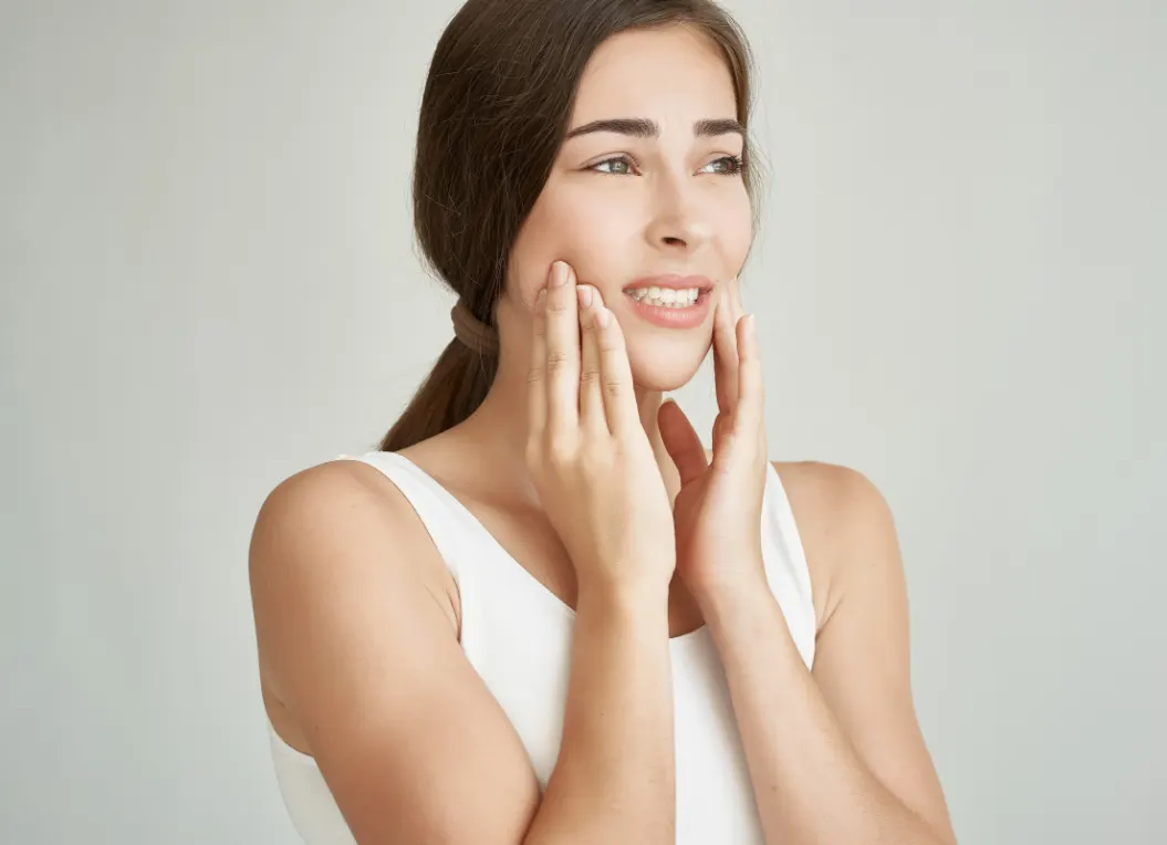 Woman experiencing tooth pain before a root canal evaluation in Flower Mound, TX