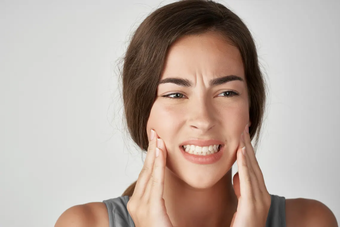 Woman experiencing severe tooth pain before a tooth extraction consultation in Flower Mound, TX.