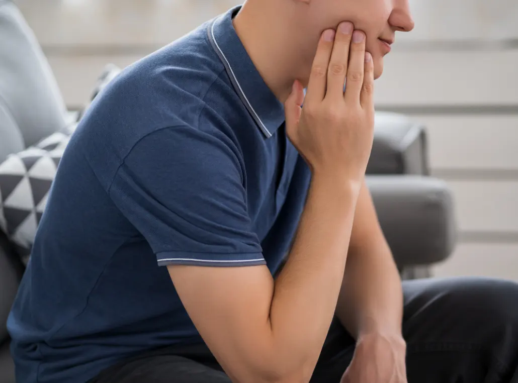 Young man experiencing jaw pain that may be related to wisdom teeth in Flower Mound, TX.